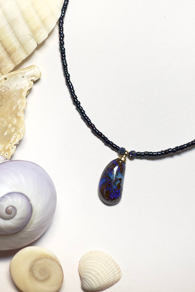 Such chic take on an opal necklace, a perfectly shaped swoop, this opal pendant has deep bright blue crystal mixed with the dark boulder, its organic and minimalist.