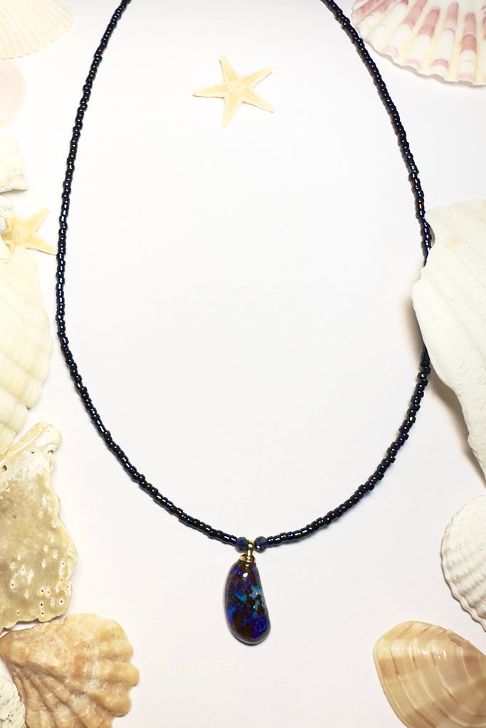 Such chic take on an opal necklace, a perfectly shaped swoop, this opal pendant has deep bright blue crystal mixed with the dark boulder, its organic and minimalist.