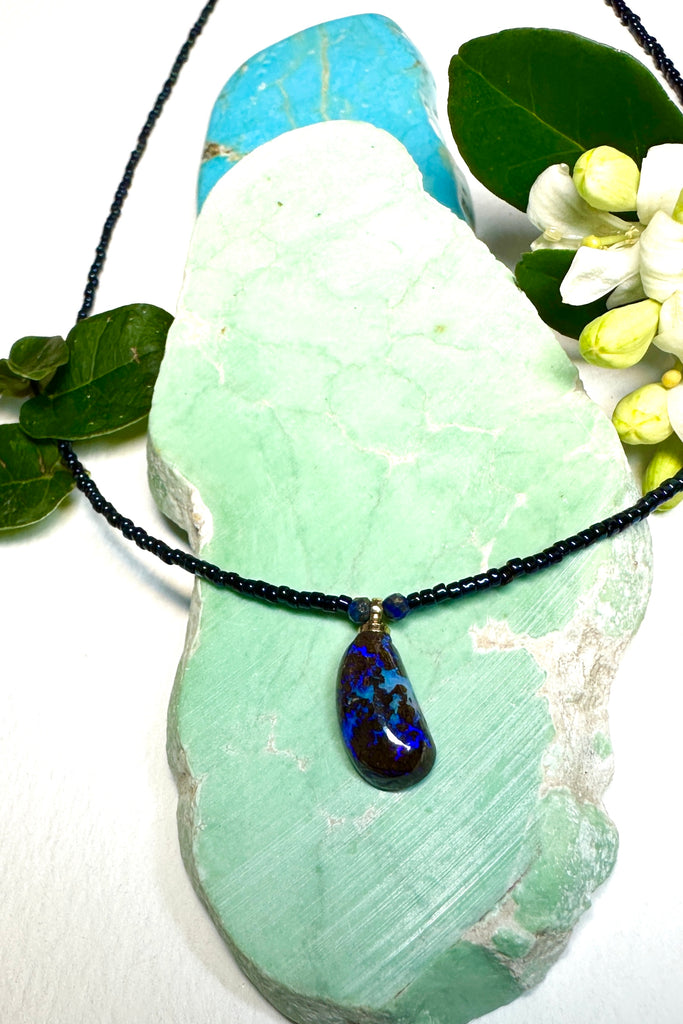 Such chic take on an opal necklace, a perfectly shaped swoop, this opal pendant has deep bright blue crystal mixed with the dark boulder, its organic and minimalist.