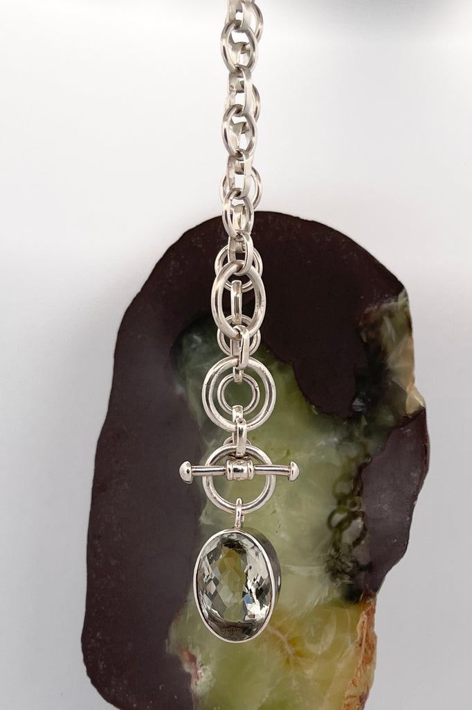 This lovely pale green faceted gemstone is beautifully faceted on both sides, set with an open back to let light in. The chain is heavy silver in choker length.