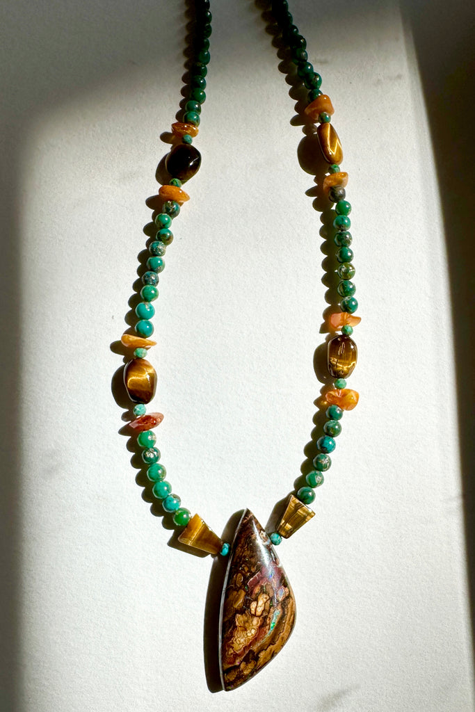 Australian Boulder Opal pendant, it has the colours of the Australian outback, transversed by pools and rivers of shiny green and blue.