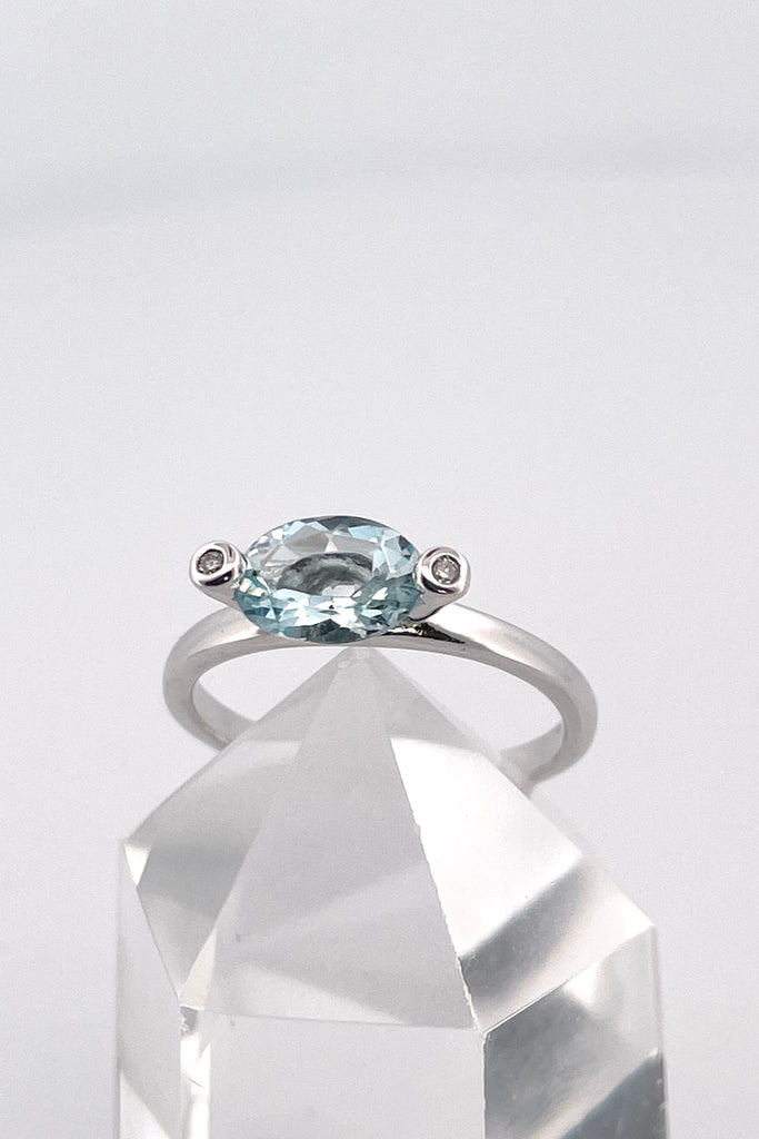 This ring gives a modern twist to antique styling. The lovely marquise cut and faceted Aquamarine is off set by two one point diamonds, one on each corner.