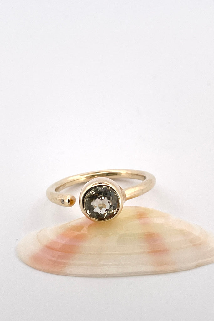 a unique modern style all of its own this stunning 10k gold ring is set with a beautiful untreated soft yellow Nigerian Tourmaline offset by a sparkling 1pt Diamond. The setting features a band that ends before the stone, leaving a tiny gap enhanced with a diamond.