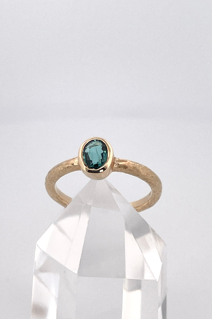 The hammered band on this ring has a slightly textured finish, giving it a hand made feel, complementing the beautiful 6x4mm natural blue tourmaline gemstone set into the ring.