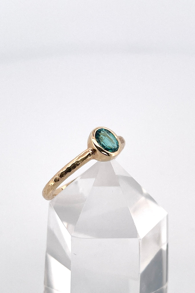 The hammered band on this ring has a slightly textured finish, giving it a hand made feel, complementing the beautiful 6x4mm natural blue tourmaline gemstone set into the ring.