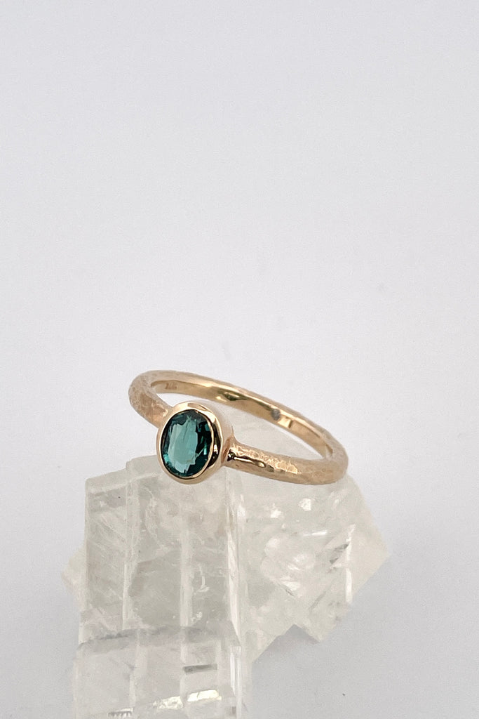 The hammered band on this ring has a slightly textured finish, giving it a hand made feel, complementing the beautiful 6x4mm natural blue tourmaline gemstone set into the ring.