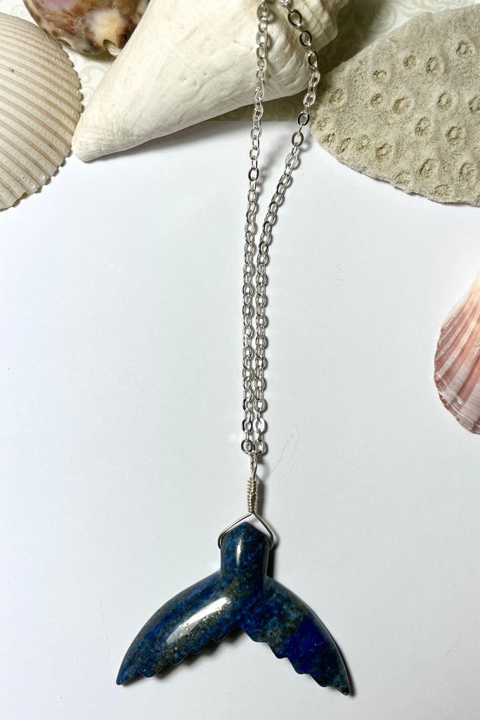 This Lapis Lazuli pendant has a centre piece which is a hand cut and carved into the shape of a whale tail.  