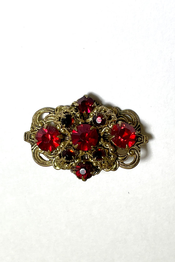 A tiny Edwadian 1910s brooch with antique gold metal set with bright red rhinestones. Such an elegant pop of colour. Condition is very good on the front, the clasp however is a bit loose.