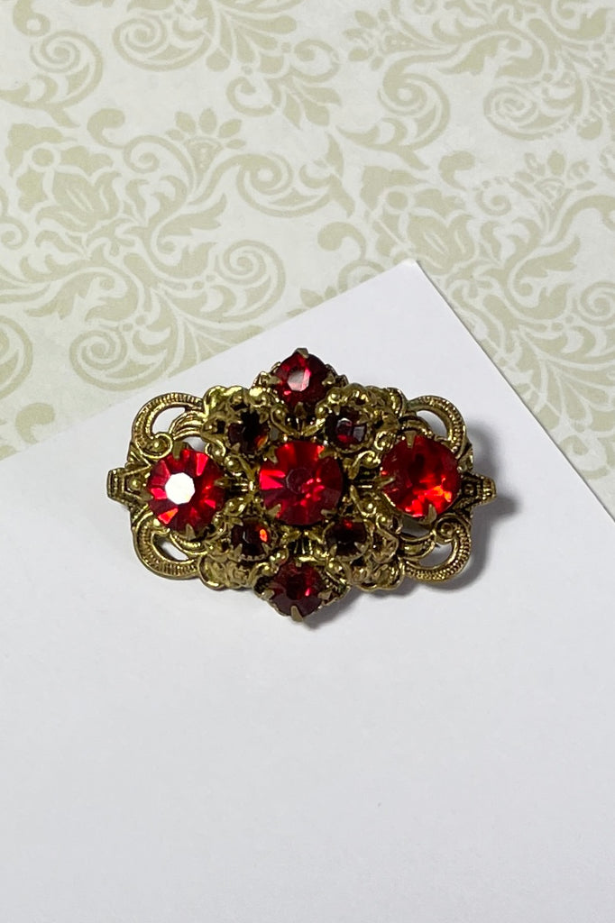 A tiny Edwadian 1910s brooch with antique gold metal set with bright red rhinestones. Such an elegant pop of colour. Condition is very good on the front, the clasp however is a bit loose.