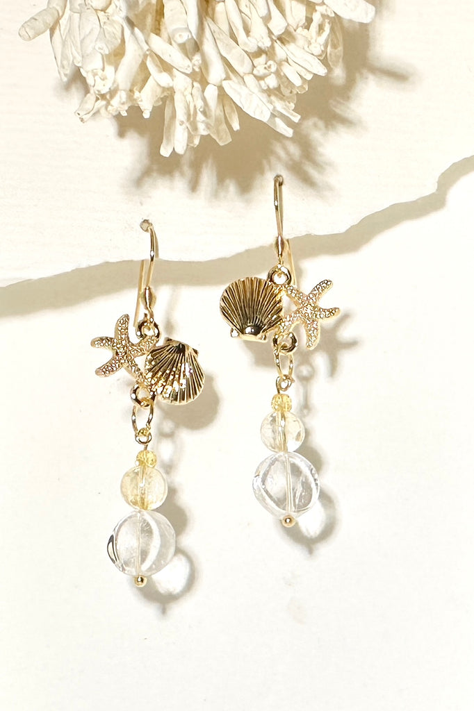 Drop earrings featuring Rock crystal and Citrine beads, a shell and starfish highlight, a perfect swing style to add a pop of summer colour.

Rock Crystal and Citrine beads with brass shell and starfish.