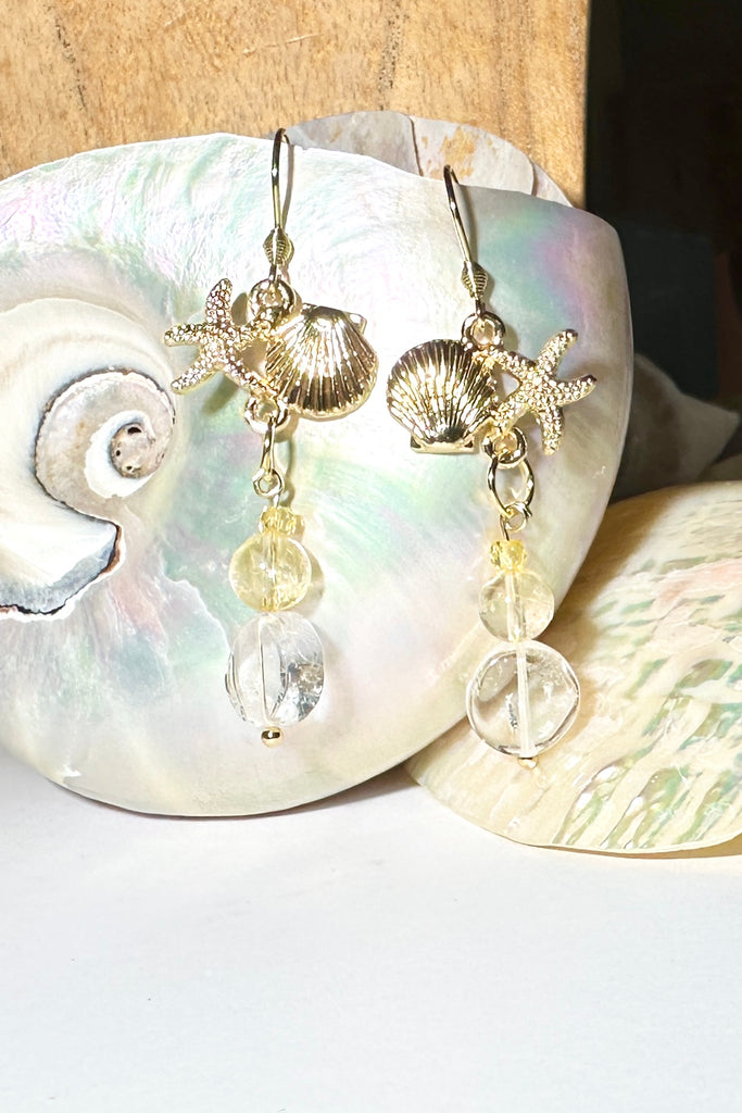 Drop earrings featuring Rock crystal and Citrine beads, a shell and starfish highlight, a perfect swing style to add a pop of summer colour.

Rock Crystal and Citrine beads with brass shell and starfish.