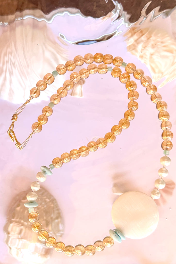 Floating bubbles of golden crystal, luminescent pearls and Mother of Pearl a ocean inspired necklace for a mermaid.

Mother of Pearl shell disc, 8mm white rondelle pearls, blue Peruvian Opal