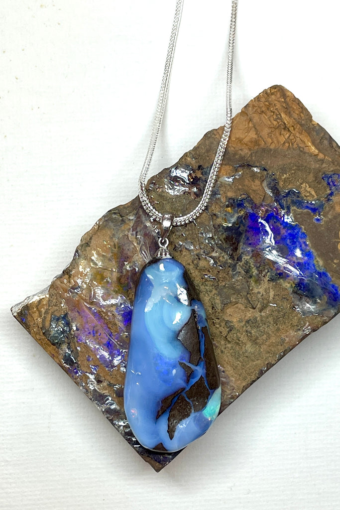A very organic natural opal piece with strong blue colour meeting the boulder down one side, it looks like the meeting of the sea and the shore.A very organic natural opal piece with strong blue colour meeting the boulder down one side, it looks like the meeting of the sea and the shore.