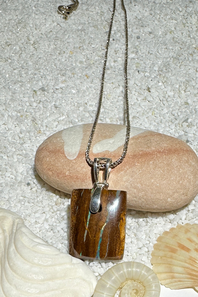 An Australian opal pendant with&nbsp; desert colours and two tiny rivers of teal blue green through the stone.