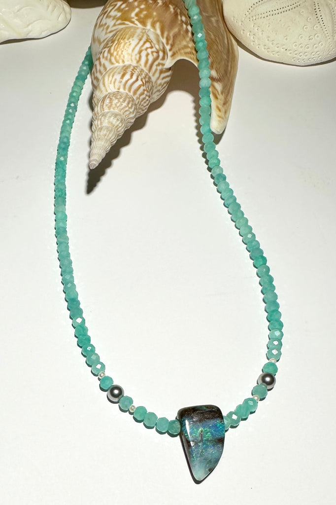 This Opal necklace has river of pale sky blue Amazonite beads and two tiny silver grey pearls, at the centre is a lake of teal blue water.

Boulder opal stone, flashing green, teal and misty blue, faceted Amazonite beads and freshwater pearls.