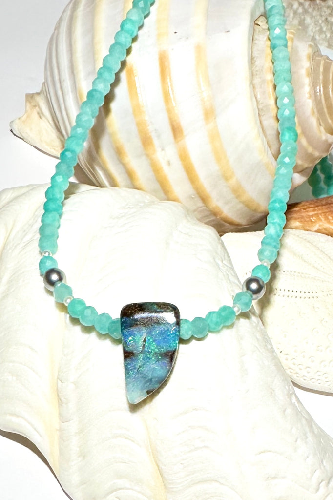 This Opal necklace has river of pale sky blue Amazonite beads and two tiny silver grey pearls, at the centre is a lake of teal blue water.

Boulder opal stone, flashing green, teal and misty blue, faceted Amazonite beads and freshwater pearls.