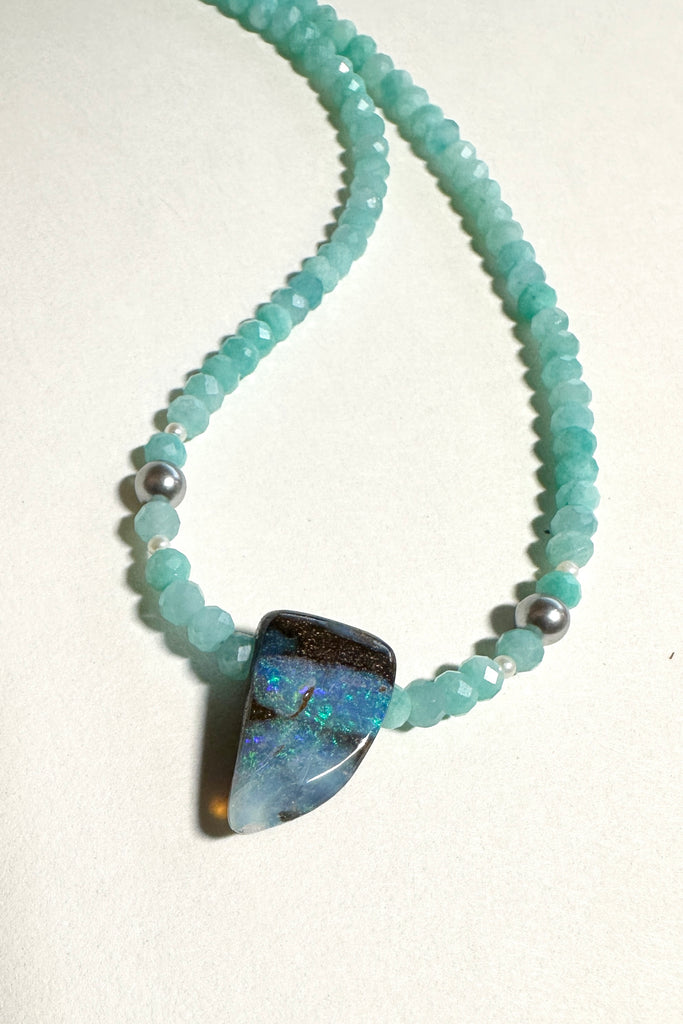This Opal necklace has river of pale sky blue Amazonite beads and two tiny silver grey pearls, at the centre is a lake of teal blue water.

Boulder opal stone, flashing green, teal and misty blue, faceted Amazonite beads and freshwater pearls.