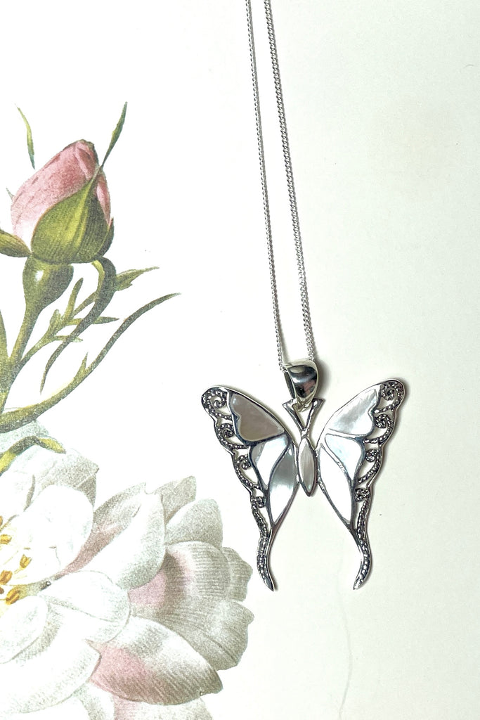 A gorgeous retro style butterfly necklace in shiny filigree silver with sea shell inlay.