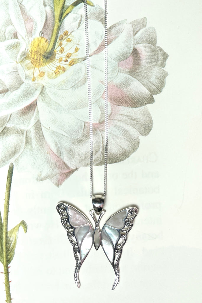 A gorgeous retro style butterfly necklace in shiny filigree silver with sea shell inlay.