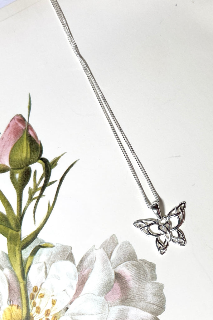 A charming butterfly necklace in shiny silver, with cut out patterns.