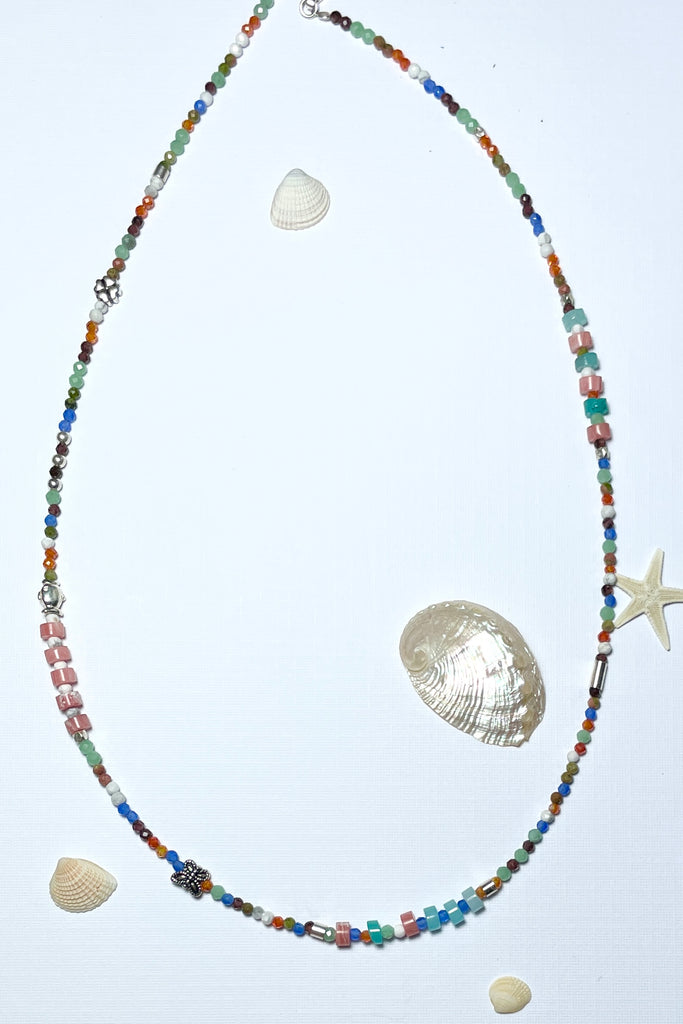 A choker style necklace made with an assortment of pretty cut, polished and faceted gemstones with silver highlight beads, this is a perfect summer beach boho style.