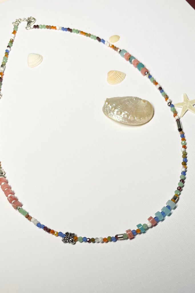 A choker style necklace made with an assortment of pretty cut, polished and faceted gemstones with silver highlight beads, this is a perfect summer beach boho style.