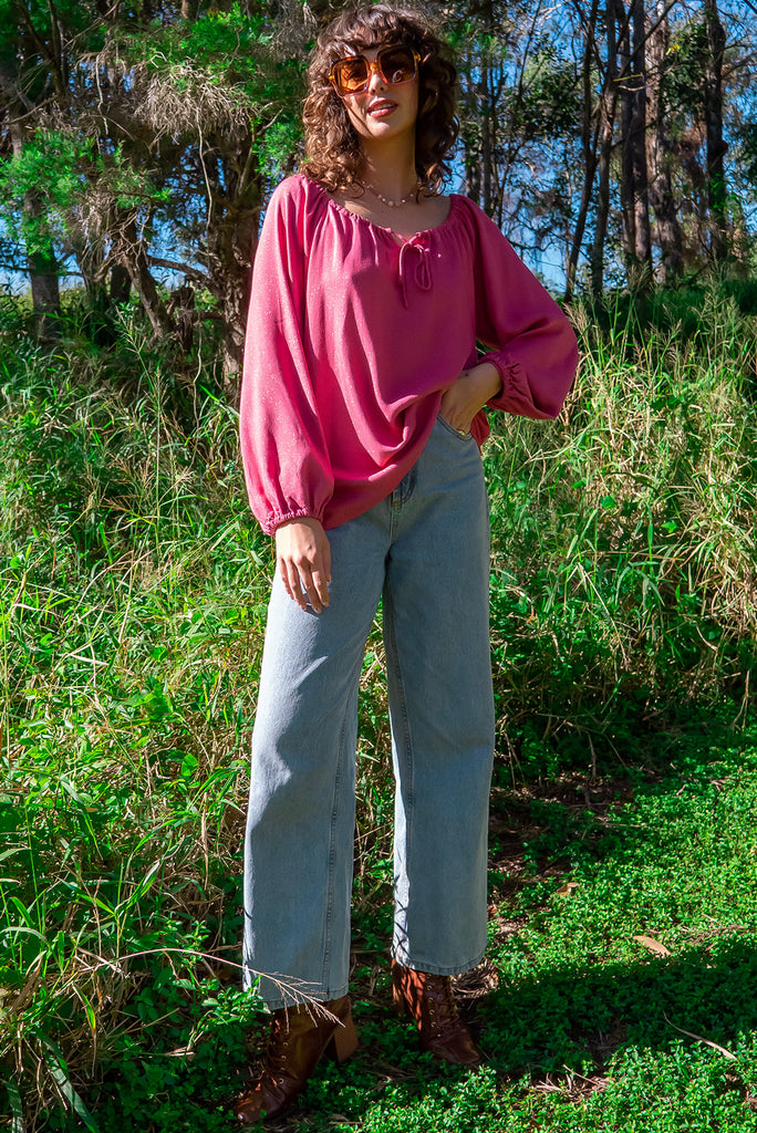 The Joni Berry Sparkle Boho Blouse is a beautiful deep pink blouse with a gold lurex shimmer all throughout. The blouse features a drawstring neckline with front keyhole and long sleeves with elasticated cuffs. Made from a woven blend of rayon, lurex, mulberry silk, and modal.