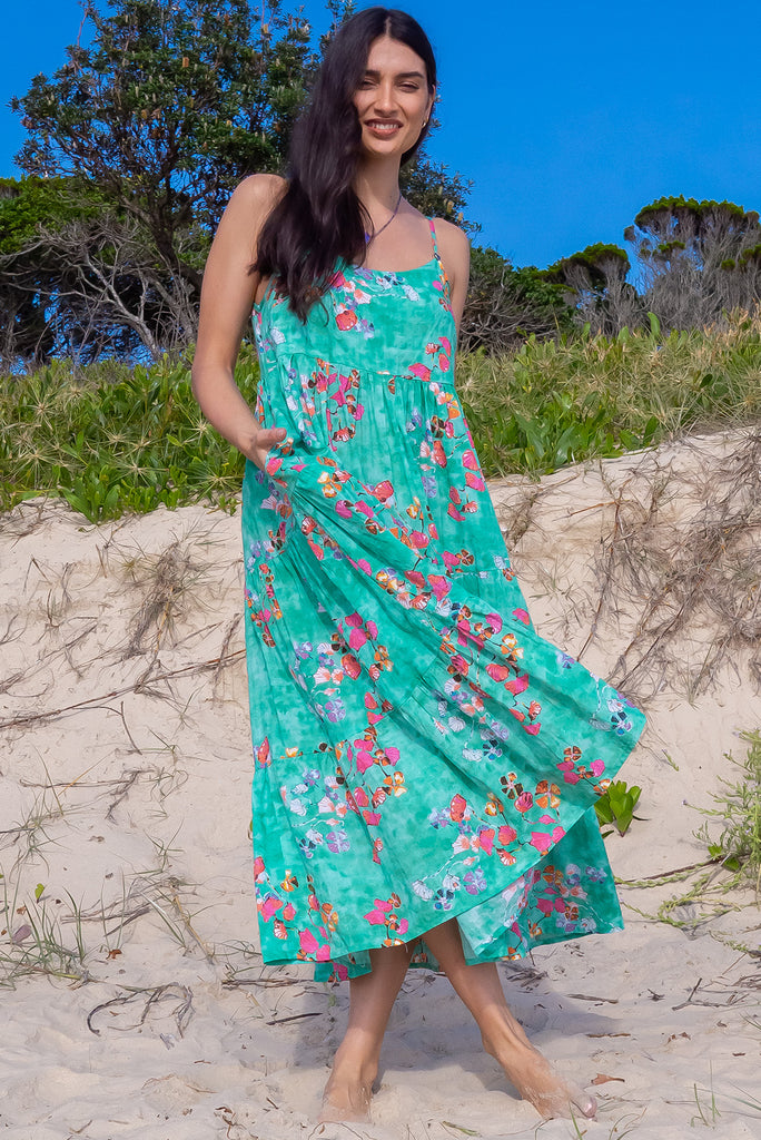 The Le Lagon Green Sea Glass Maxi Dress is a gorgeous sea green maxi dress with a green wash effect base and botanical print. The dress features silver heart beads on the shoulder straps, tiered skirting and side pockets. Made from a woven blend of cotton and rayon.