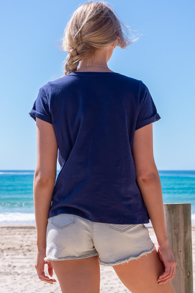 The Lei Tee Midnight Sail Shirt is beautiful navy blue t-shirt. The tee features a split neckline, rolled sleeve cuffs, and a gathered bust panel. Made from knit cotton.
