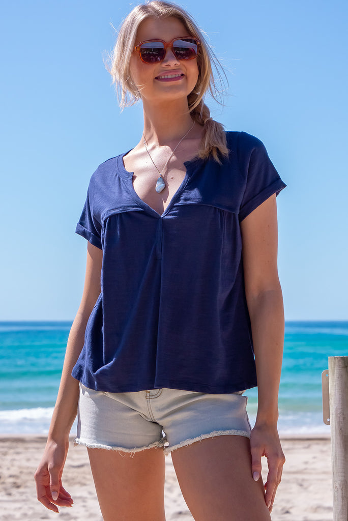 The Lei Tee Midnight Sail Shirt is beautiful navy blue t-shirt. The tee features a split neckline, rolled sleeve cuffs, and a gathered bust panel. Made from knit cotton.