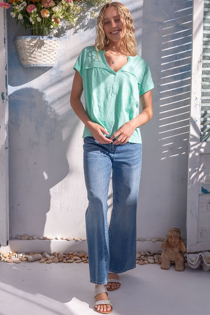 The Lei Tee Sea Green Shirt is a gorgeous pale green t-shirt. The tee features a split neckline, rolled sleeve cuffs, and a gathered bust panel. Made from knit cotton.