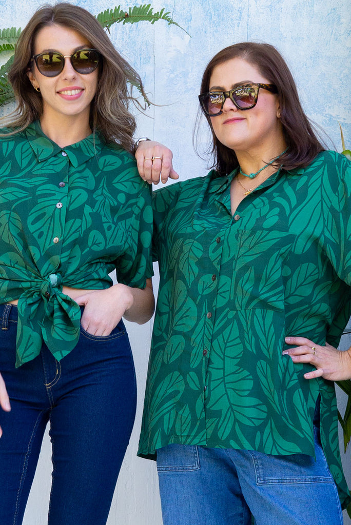 The Leonora Botany Green Short Sleeve Shirt is a tonal green relaxed fit button down shirt with botanical leaf print. The blouse features short sleeves, button down front, classic collar, one bust pocket, side slits, scooped hem at sides and slightly longer back. Made from woven 100% rayon.