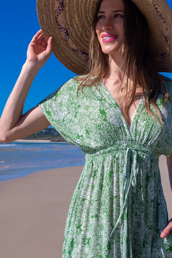 The Linden Green Blooms Maxi Dress is a gorgeous green maxi dress with a with white floral outline print. The dress features dollar sleeves, an elasticated and drawstring empire line, v-neckline, and side pockets. Made from crinkle rayon.