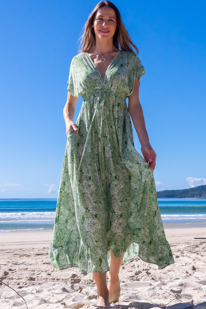 The Linden Green Blooms Maxi Dress is a gorgeous green maxi dress with a with white floral outline print. The dress features dollar sleeves, an elasticated and drawstring empire line, v-neckline, and side pockets. Made from crinkle rayon.