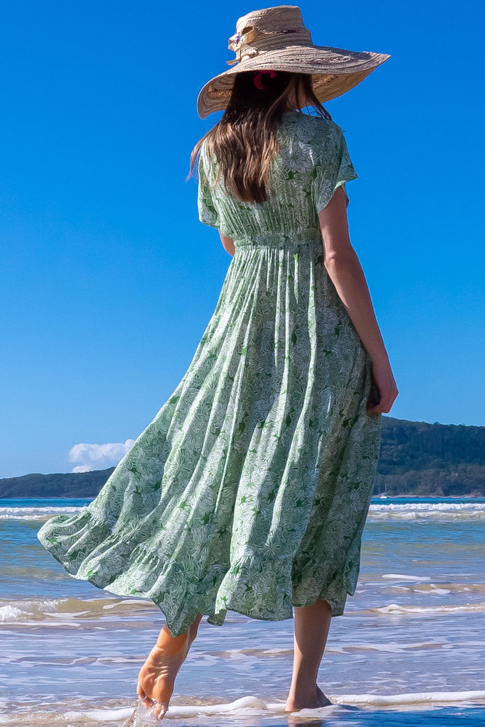 The Linden Green Blooms Maxi Dress is a gorgeous green maxi dress with a with white floral outline print. The dress features dollar sleeves, an elasticated and drawstring empire line, v-neckline, and side pockets. Made from crinkle rayon.