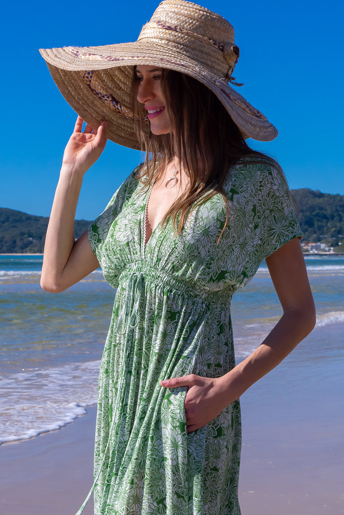 The Linden Green Blooms Maxi Dress is a gorgeous green maxi dress with a with white floral outline print. The dress features dollar sleeves, an elasticated and drawstring empire line, v-neckline, and side pockets. Made from crinkle rayon.