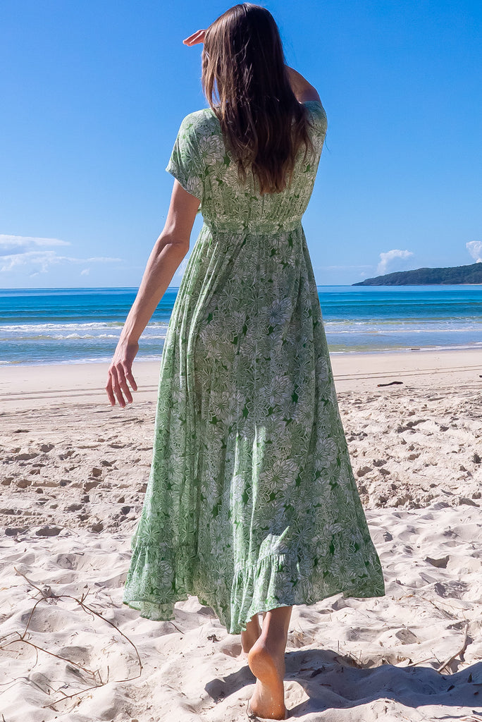 The Linden Green Blooms Maxi Dress is a gorgeous green maxi dress with a with white floral outline print. The dress features dollar sleeves, an elasticated and drawstring empire line, v-neckline, and side pockets. Made from crinkle rayon.