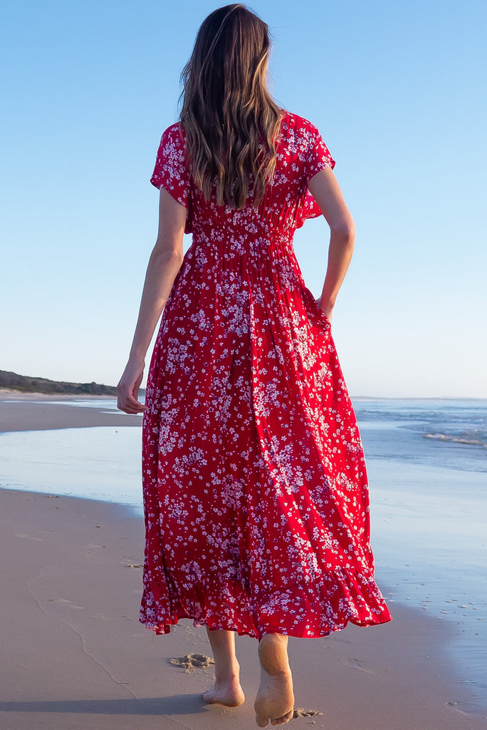 The Linden Red Flora Maxi Dress is a gorgeous red maxi dress with a white cherry blossom print. The dress features dollar sleeves, an elasticated and drawstring empire line, v-neckline, and side pockets. Made from crinkle rayon.