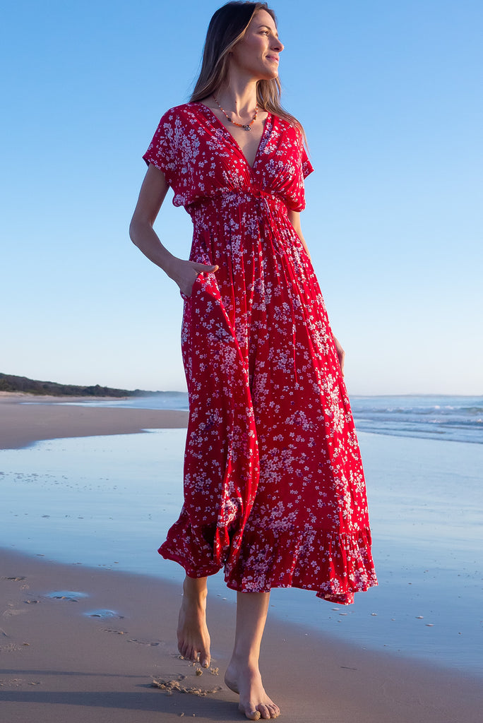 The Linden Red Flora Maxi Dress is a gorgeous red maxi dress with a white cherry blossom print. The dress features dollar sleeves, an elasticated and drawstring empire line, v-neckline, and side pockets. Made from crinkle rayon.