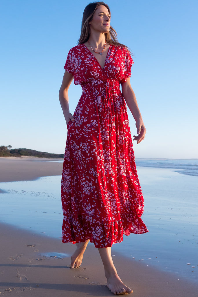 The Linden Red Flora Maxi Dress is a gorgeous red maxi dress with a white cherry blossom print. The dress features dollar sleeves, an elasticated and drawstring empire line, v-neckline, and side pockets. Made from crinkle rayon.