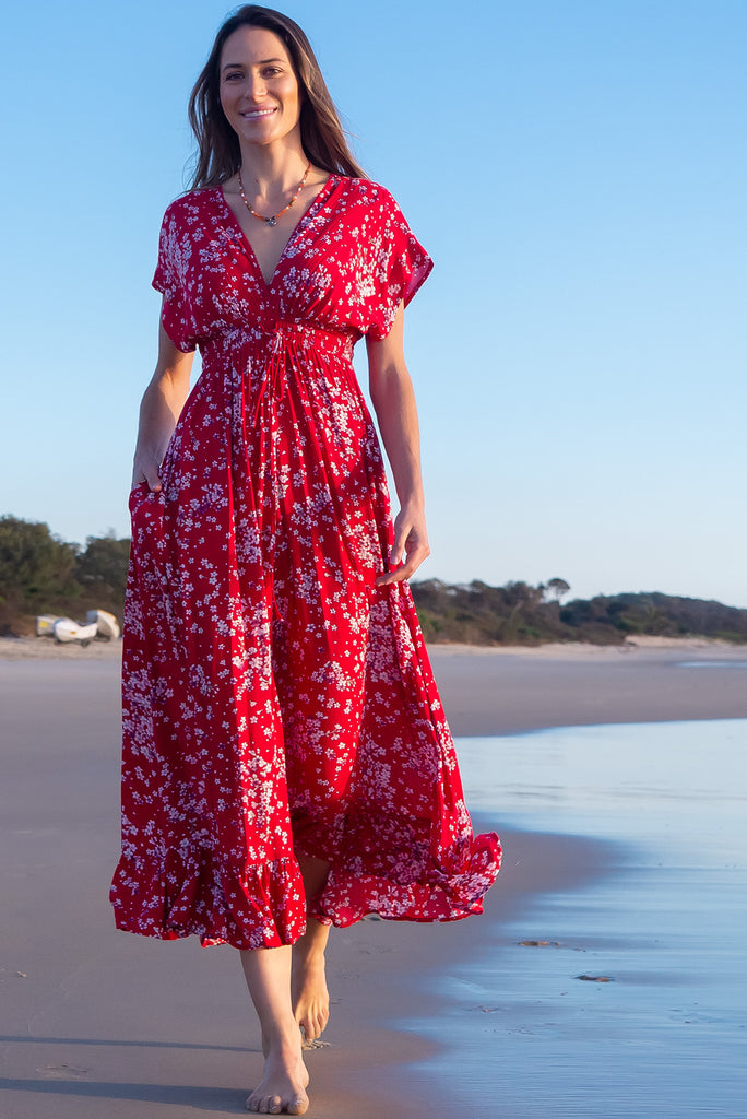 The Linden Red Flora Maxi Dress is a gorgeous red maxi dress with a white cherry blossom print. The dress features dollar sleeves, an elasticated and drawstring empire line, v-neckline, and side pockets. Made from crinkle rayon.