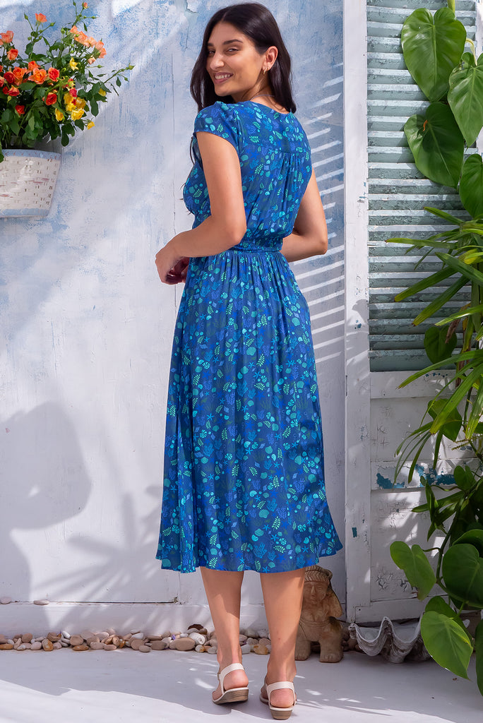 The Lizzie Sea Shells Blue Midi Dress is a beautiful blue midi dress with a cool toned small shell print all over. The dress features a basque waist, feminine cut and gathered bust. Made from 100% rayon.  