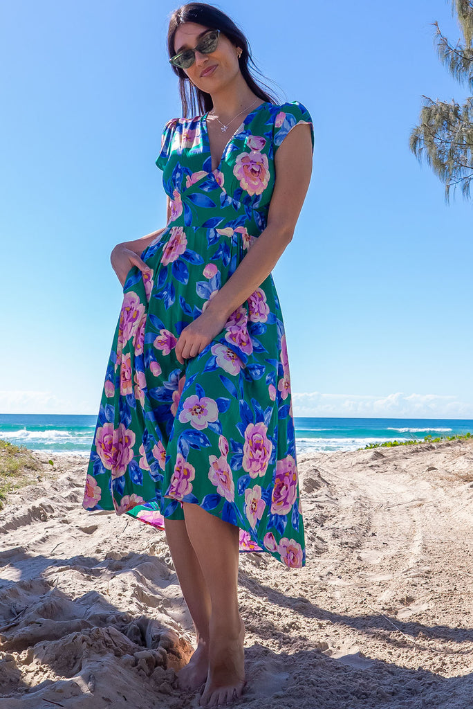 The Lizzie Green Tambourine Dress is a gorgeous green midi dress with a large retro floral print. The dress features cap sleeves, a deep v neckline, fitted Basque waist with gathered bust, elastic shirring at back waist, side pockets and is made from woven 100% rayon.