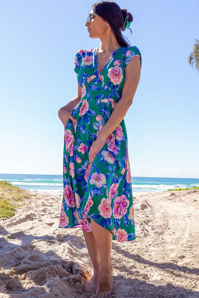 The Lizzie Green Tambourine Dress is a gorgeous green midi dress with a large retro floral print. The dress features cap sleeves, a deep v neckline, fitted Basque waist with gathered bust, elastic shirring at back waist, side pockets and is made from woven 100% rayon.