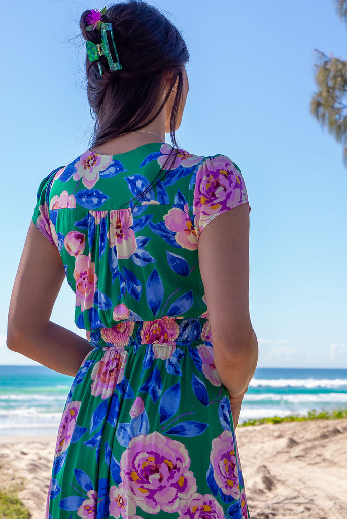 The Lizzie Green Tambourine Dress is a gorgeous green midi dress with a large retro floral print. The dress features cap sleeves, a deep v neckline, fitted Basque waist with gathered bust, elastic shirring at back waist, side pockets and is made from woven 100% rayon.