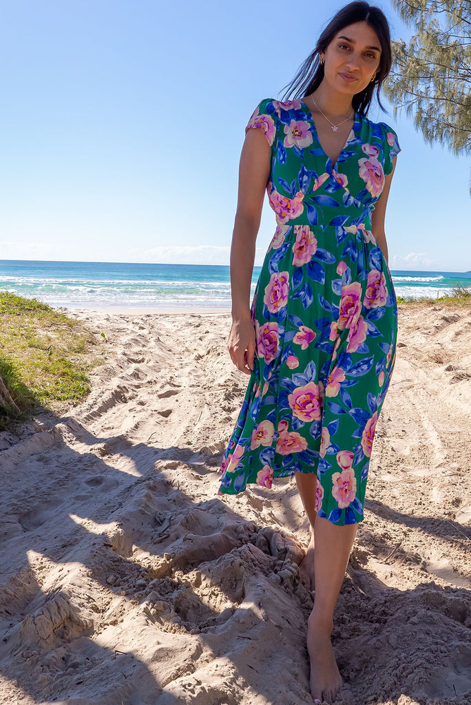 The Lizzie Green Tambourine Dress is a gorgeous green midi dress with a large retro floral print. The dress features cap sleeves, a deep v neckline, fitted Basque waist with gathered bust, elastic shirring at back waist, side pockets and is made from woven 100% rayon.