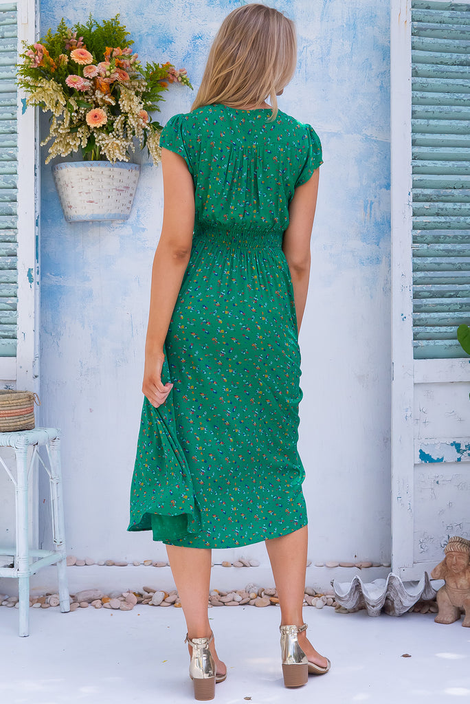 The Lizzie Greenery Midi Dress is a gorgeous green dress with a ditzy floral print. The midi dress features cap sleeves, a deep v neckline, fitted basque waist with gathered bust, elastic shirring at back waist, side pockets and is made from woven 100% rayon.