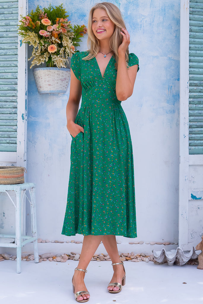 The Lizzie Greenery Midi Dress is a gorgeous green dress with a ditzy floral print. The midi dress features cap sleeves, a deep v neckline, fitted basque waist with gathered bust, elastic shirring at back waist, side pockets and is made from woven 100% rayon.