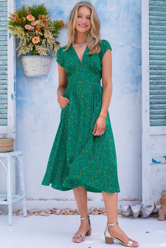 The Lizzie Greenery Midi Dress is a gorgeous green dress with a ditzy floral print. The midi dress features cap sleeves, a deep v neckline, fitted basque waist with gathered bust, elastic shirring at back waist, side pockets and is made from woven 100% rayon.