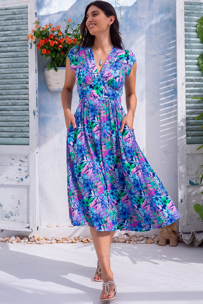 The Lizzie Leaf Blue Midi Dress is a beautiful blue midi dress with a vibrant leaf print. The dress features a basque waist, feminine cut and gathered bust. Made from 100% rayon. 